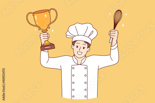 Man chef cook celebrates victory in professional culinary tournament, holds golden cup and whisk in hands. Restaurant chef in white uniform and hat won speed-cooking delicacy competition