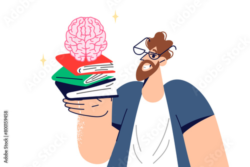 Man student studies from books to prepare for exams at university, holds textbooks and brain in hand