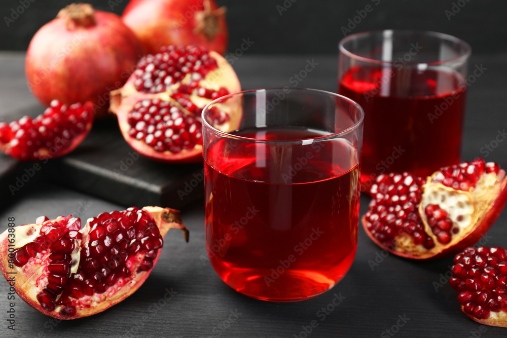 Tasty pomegranate juice in glasses and fresh fruits on black wooden table, closeup Tasty pomegranate juice in glasses and fresh fruits on black wooden table, closeup