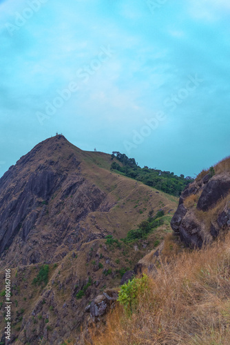 A mountain with a cloudy sky in the background