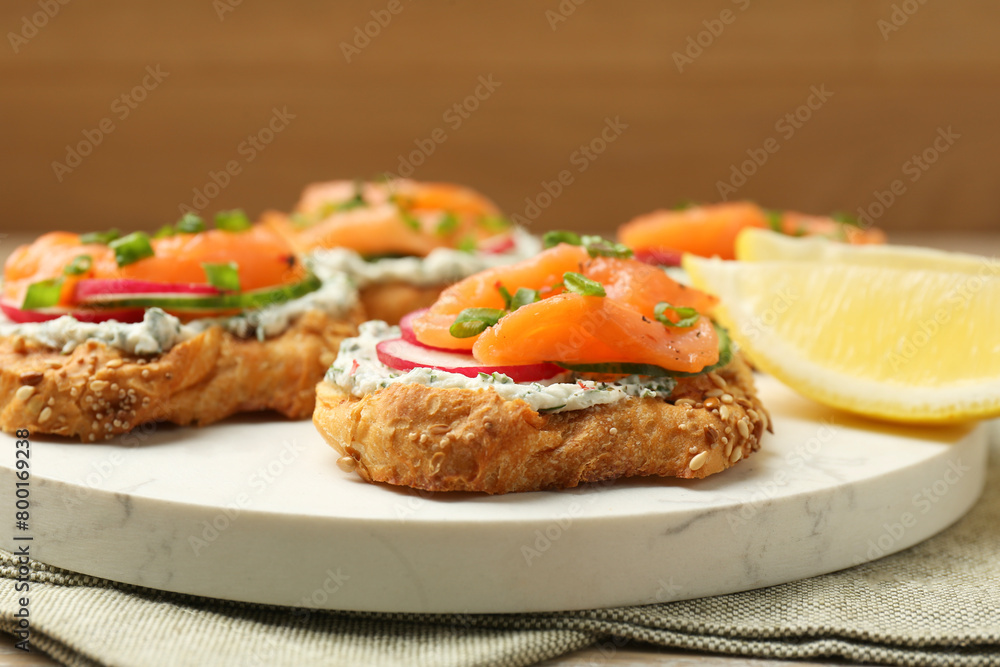 Tasty canapes with salmon, cucumber, radish and cream cheese on table, closeup Tasty canapes with salmon, cucumber, radish and cream cheese on table, closeup