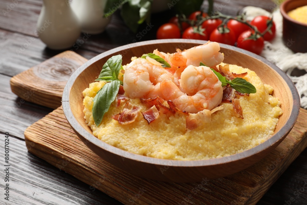 Fresh tasty shrimps, bacon, grits and basil in bowl on wooden table, closeup Fresh tasty shrimps, bacon, grits and basil in bowl on wooden table, closeup