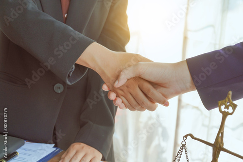  Shakinghands, A group of lawyers and clients engage in a professional meeting at a law office, discussing agreements, contracts, and legal matters with a focus on justice and expert advice.