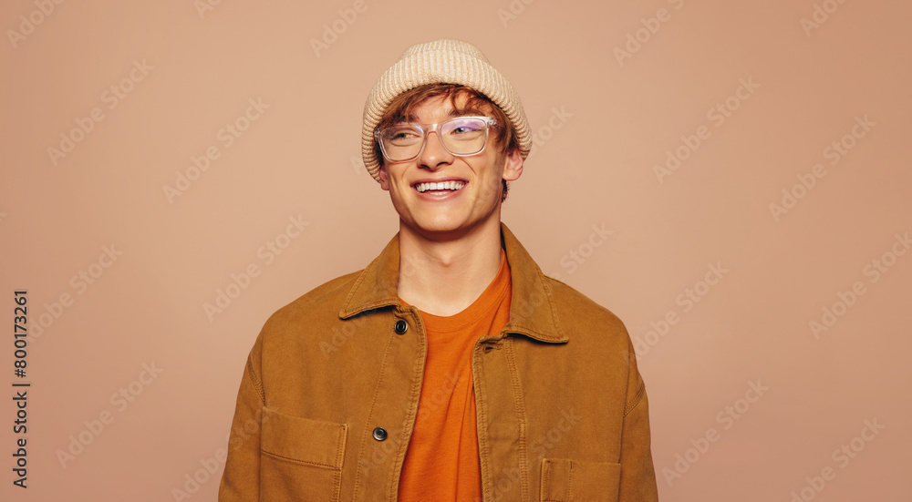 Obraz premium Stylish man in denim jacket and glasses on peach background