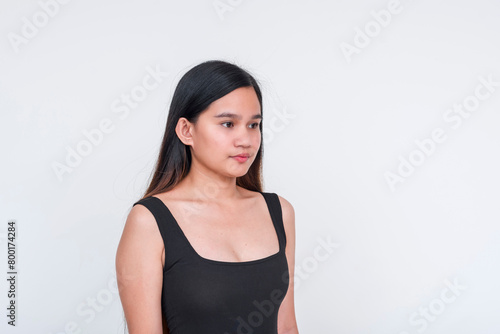 Elegant young Asian woman posing in a sleek black bodysuit, isolated on white background photo