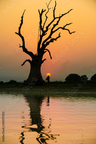 Silhouete of a person with the sun setting behind his head in Myanmar