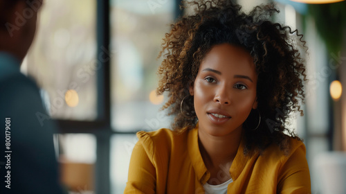 A photograph of a biracial woman engaging in a dynamic conversation with interviewers photo