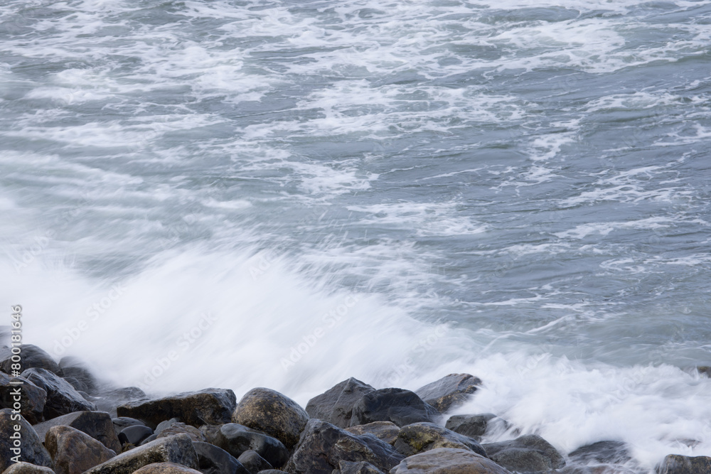 Obraz premium Ocean waves crashing on a rocky shore
