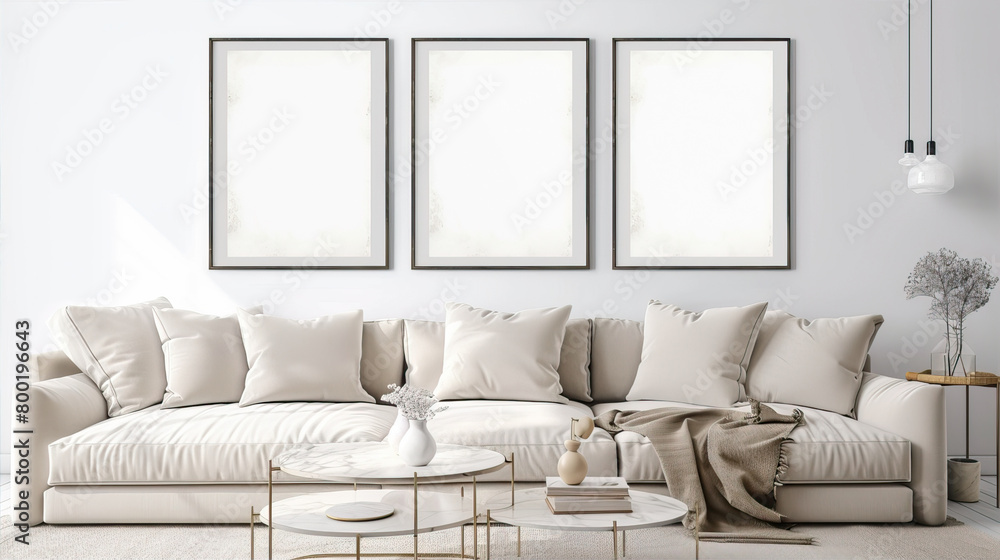 Fototapeta premium Three blank white posters in the room above the sofa 