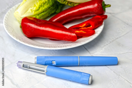 Original Danish Ozempic Insulin injection pen for diabetics and plate with vegetables. photo