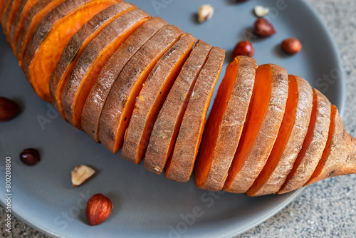 Roasted hasselback sweet potatoes with hazelnuts close-up