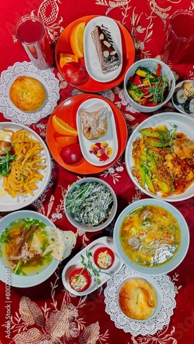 top view of Uzbek traditional dishes on a table with red tablecloth