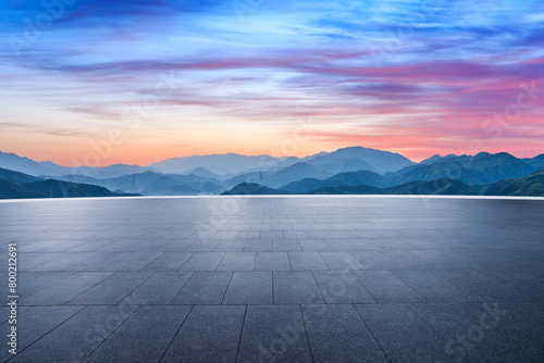 Empty square floor and green mountain with sky clouds at dusk
