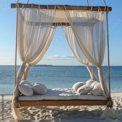 wooden swing with a mattress and pillows under a canopy on the tropical beach © CREATIVE STOCK