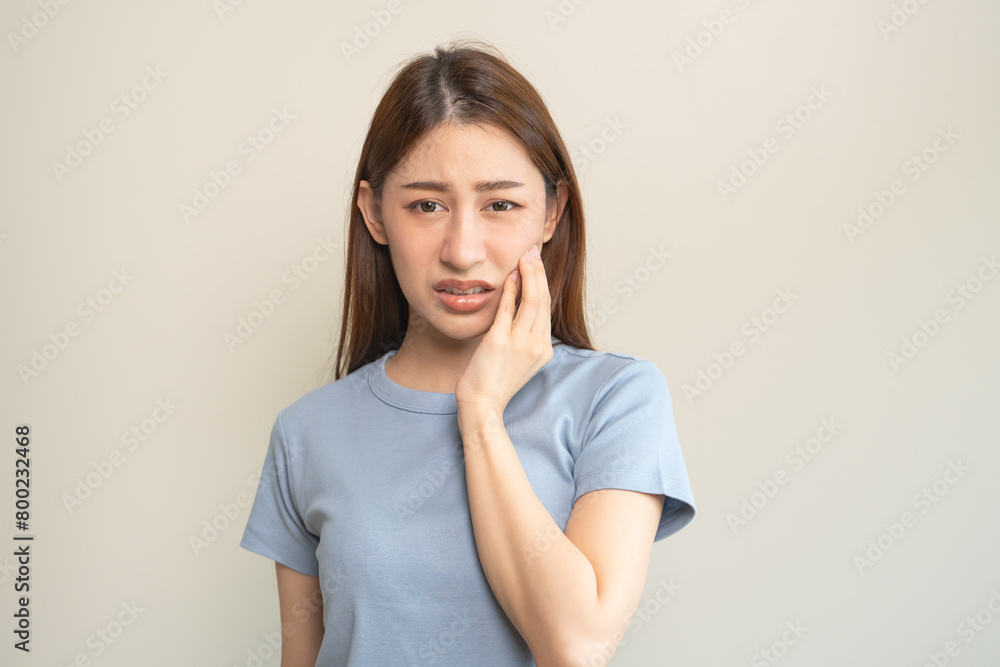 Face expression suffering from sensitive teeth, Asian young woman touching cheek Face expression suffering from sensitive teeth, Asian young woman touching cheek