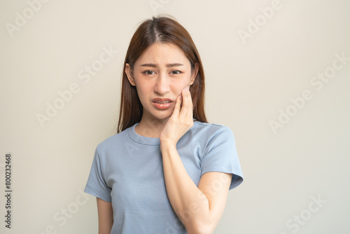 Face expression suffering from sensitive teeth, Asian young woman touching cheek © Pormezz