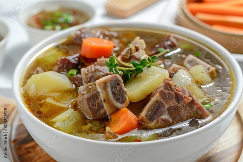 Indonesian beef ribs soup served in white bowl with focus on ingredients
