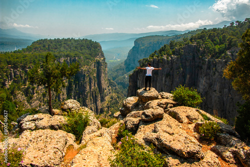 Fotografie Man opens his arms and watches the fascinating nature view