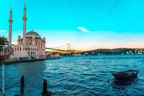 A mosque with a blue sky in the background. Ortakoy Mosque, Besiktas Turkey. A mosque in Istanbul with the bridge in the background.