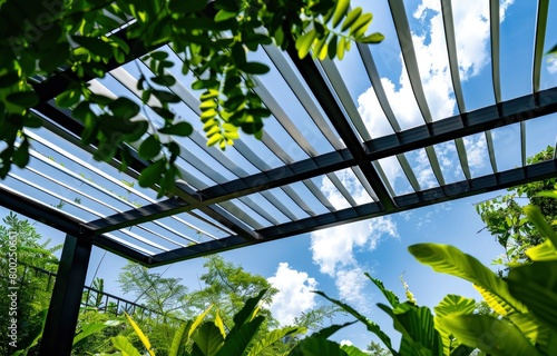 Modern louring canopy with white slats, set against the backdrop of blue sky and lush greenery. photo