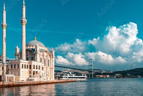A mosque with a blue sky in the background. Ortakoy Mosque, Besiktas Turkey. A mosque in Istanbul with the bridge in the background.