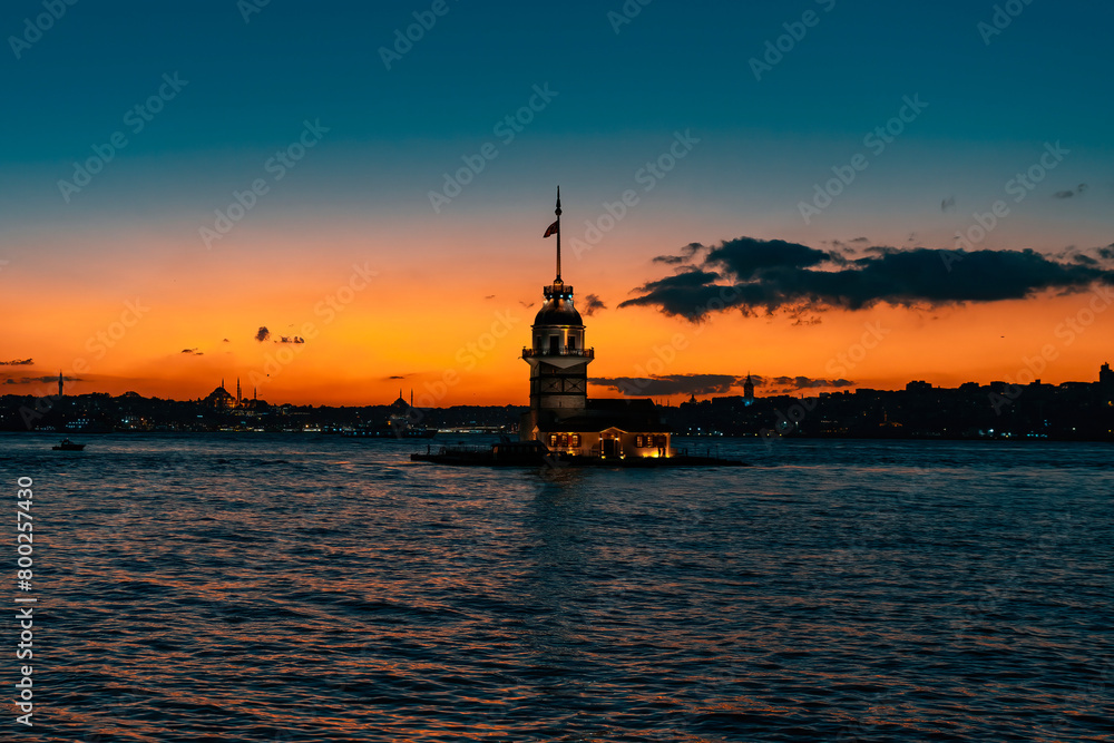 Fiery sunset over the Bosphorus with the famous Maiden's Tower, the symbol of Istanbul. Wallpaper or scenic travel background.
