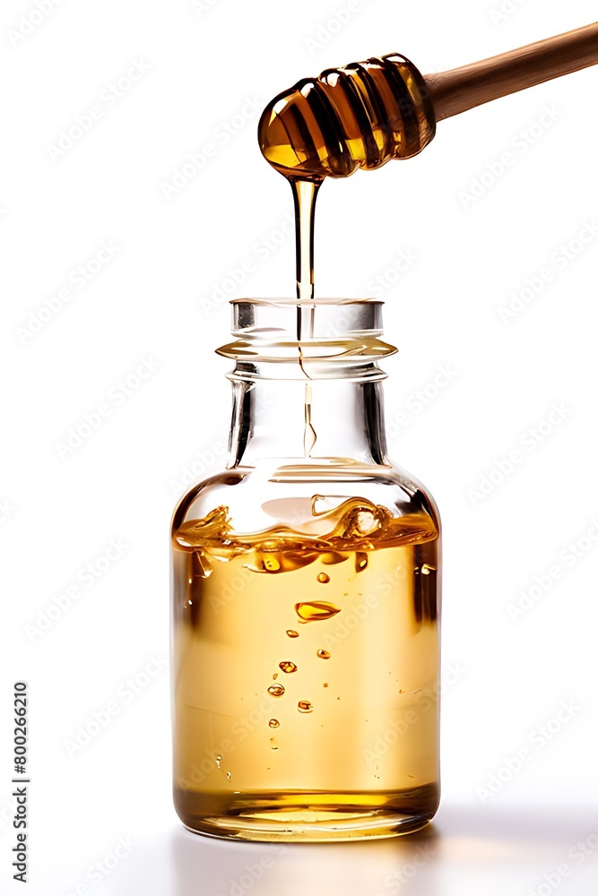 A jar of honey with a dipper, against a white backdrop Jar of honey and wooden drizzler isolated on white.