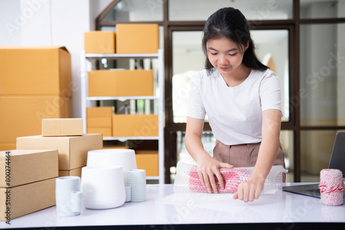 Small business entrepreneur woman packing product in mailing box for shipping from online store. Business online shipping and delivery concept.