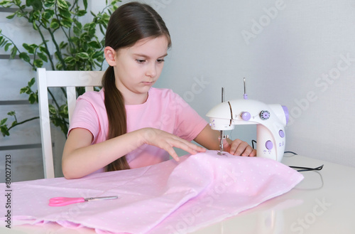 Teenage girl prepares sewing machine for work, inserts thread. Hobby sewing as small business concept.
