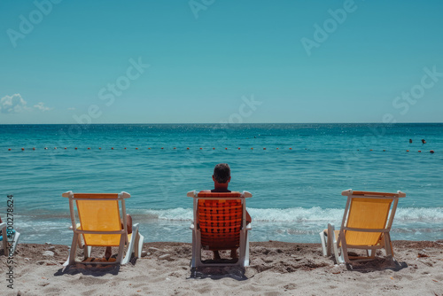 man in a sun lounger sunbathing on the beach
