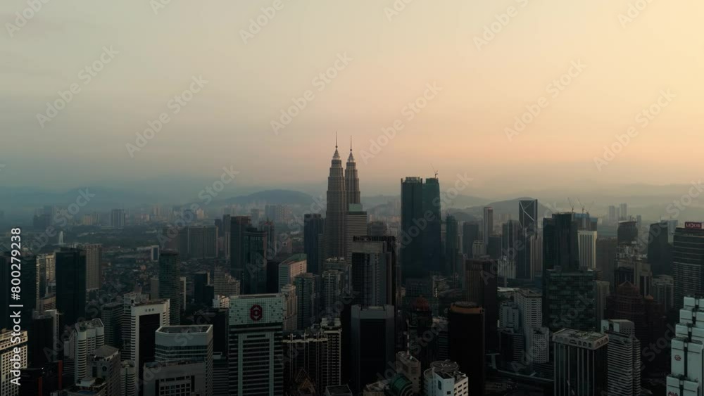 Drone shot of the Kuala Lumpur skyline at sunrise, focusing on the Petronas Towers. Drone shot of the Kuala Lumpur skyline at sunrise, focusing on the Petronas Towers.