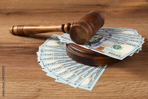 Judge's gavel and money on wooden table