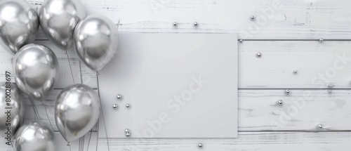 Silver balloons and empty white card on wooden background photo