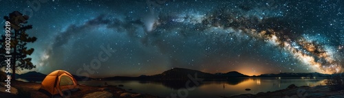 Starry night sky over a lit camping tent and a lone tree in a grassy field