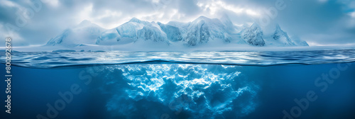 A unique split-view captures the icy mountains above and the serene underwater world below in a tranquil landscape