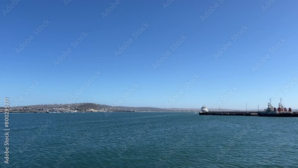 Harbor with a ship tied to the jetty with a cruise ship out at sea Harbor with a ship tied to the jetty with a cruise ship out at sea