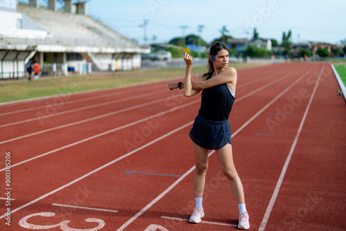 Beautiful Asian girl running at outdoor treadmill in sports stadium, Taking care of health and exercise for modern teenagers.