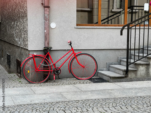 Red bicycle near the porch. Steps. European provincial town.