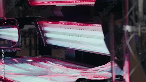 Open tanning bed with glowing ultraviolet lamps and reflective surface photo