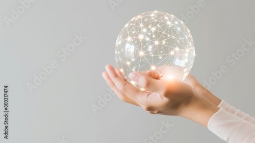 A hand gently holding a translucent sphere with a glowing digital network, symbolizing connectivity and technology. photo