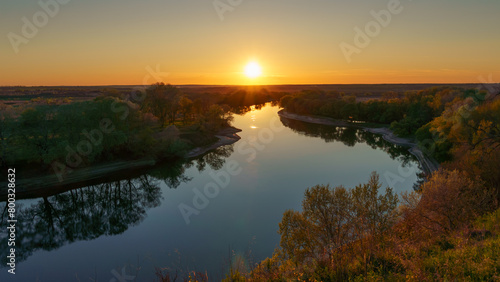 beautiful spring landscape, panoramic view of river and forest from above the hill, bright sunny day turns into sunset and dusk, sunlight reflects from water, river bank and flow of water