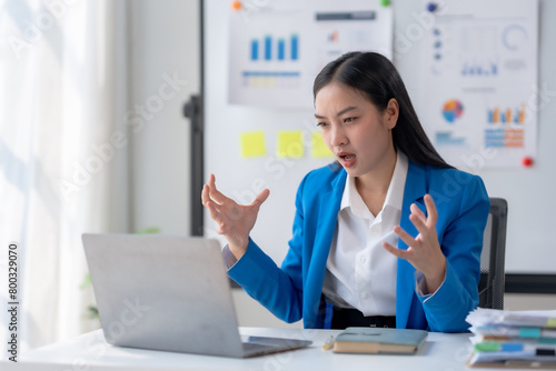 Frustrated asian businesswoman experiencing stress at work.