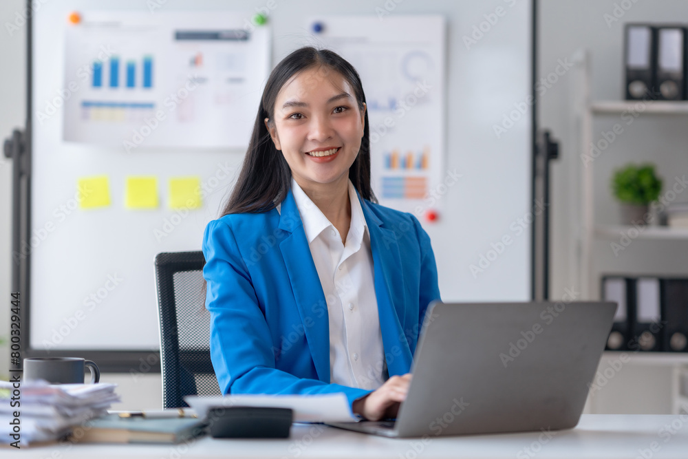 Happy smiling Asian businesswoman using laptop computer in the office. Beautiful young Asian female shopping or chatting online in social networks, freelance working on laptop projects. Happy smiling Asian businesswoman using laptop computer in the office. Beautiful young Asian female shopping or chatting online in social networks, freelance working on laptop projects.