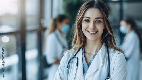 Young happy female doctor standing in medical hospital background. Woman physician therapist or obstetrician wearing uniform looking at camera in clinic. Healthcare medicine concept. Portrait. photo