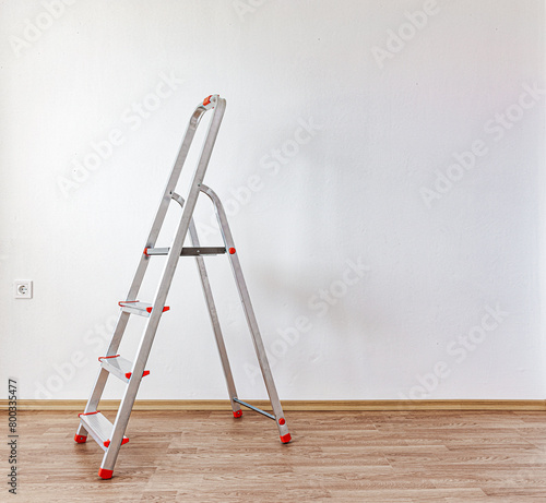 Leiter in einem leeren Zimmer mit Parkettboden