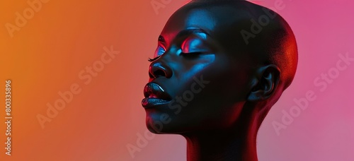 A bald black woman with closed eyes is illuminated by neon light against the background of a gradient color.