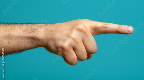  A hand with a finger emphasizing, pointed towards camera on a blue backdrop