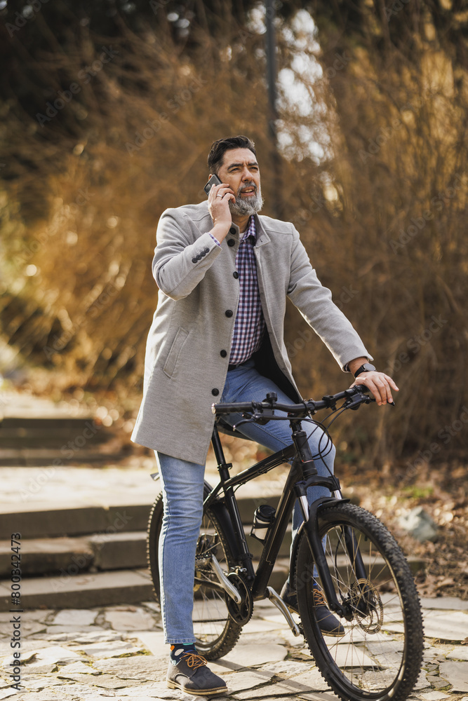 Man Talking on Cell Phone While Riding Bike in Park Man Talking on Cell Phone While Riding Bike in Park