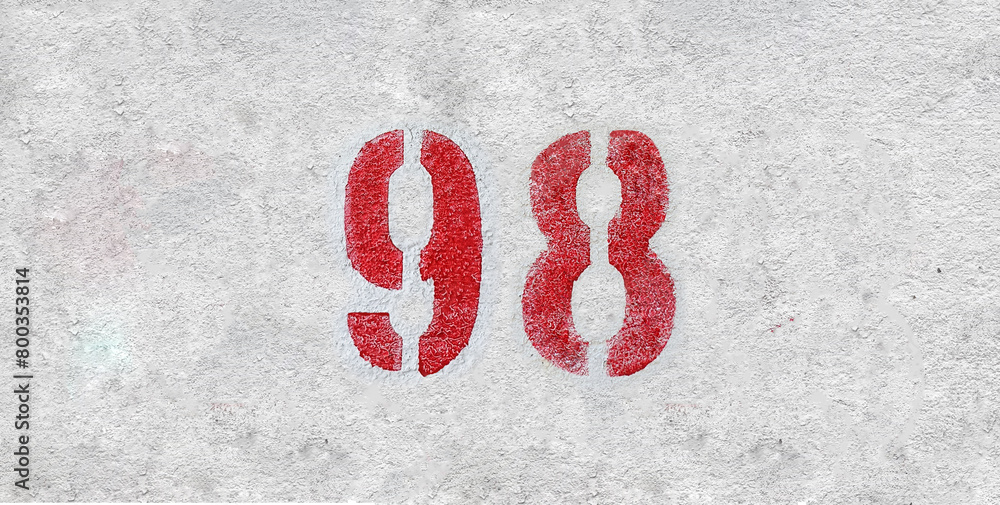 Red Number 98 on the white wall. Spray paint.
