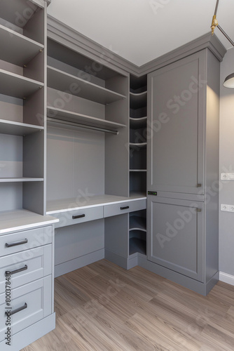 A grey and white wardrobe with shelves  light gray walls  neutral colors  modern design  light wood floor